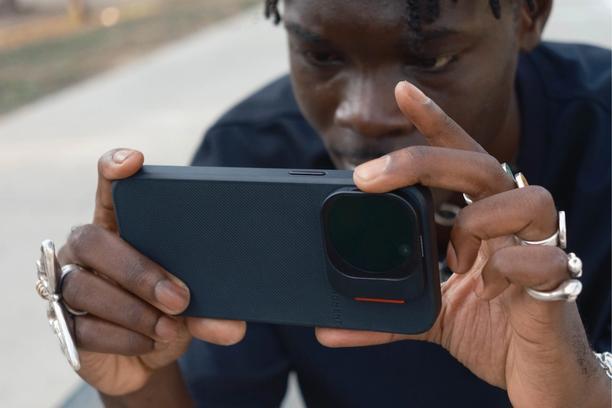 Creator using the iPhone 16 with a camera case in blue and QuickLock filters.