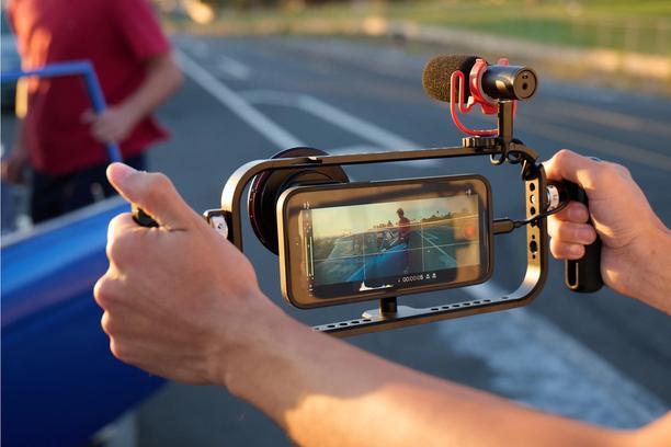 The iPhone 16 shooting in the Moment Pro Camera app real-life footage as dusk with a shotgun mic, filters, and a Moment Filmmaker cage.