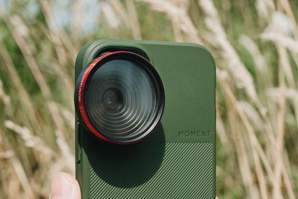 Moment's 37mm Phone Filter Mount on a Green camera case for iPhone 16.